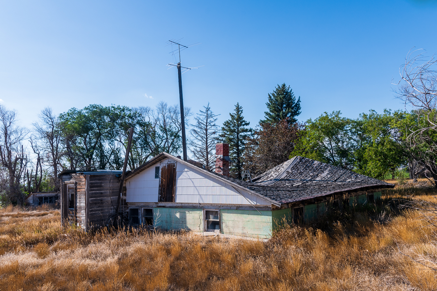 The ruins of a home that the roof has collapsed straight down onto the foundation in Huntley Wyoming Post Office. © Hawk Buckman