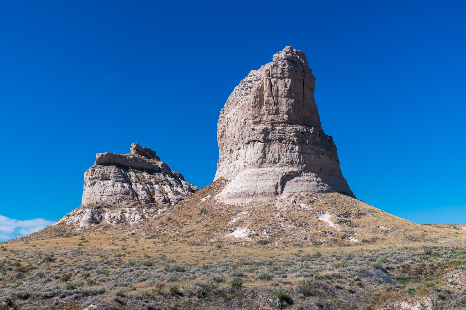 Layers in the matrix of Courthouse and Jail Rock show Brule clay, Gering sandstone, and Volcanic ash with sandstone being found at the bottom, sand, and ash near the middle and top of the promontories. © Hawk Buckman